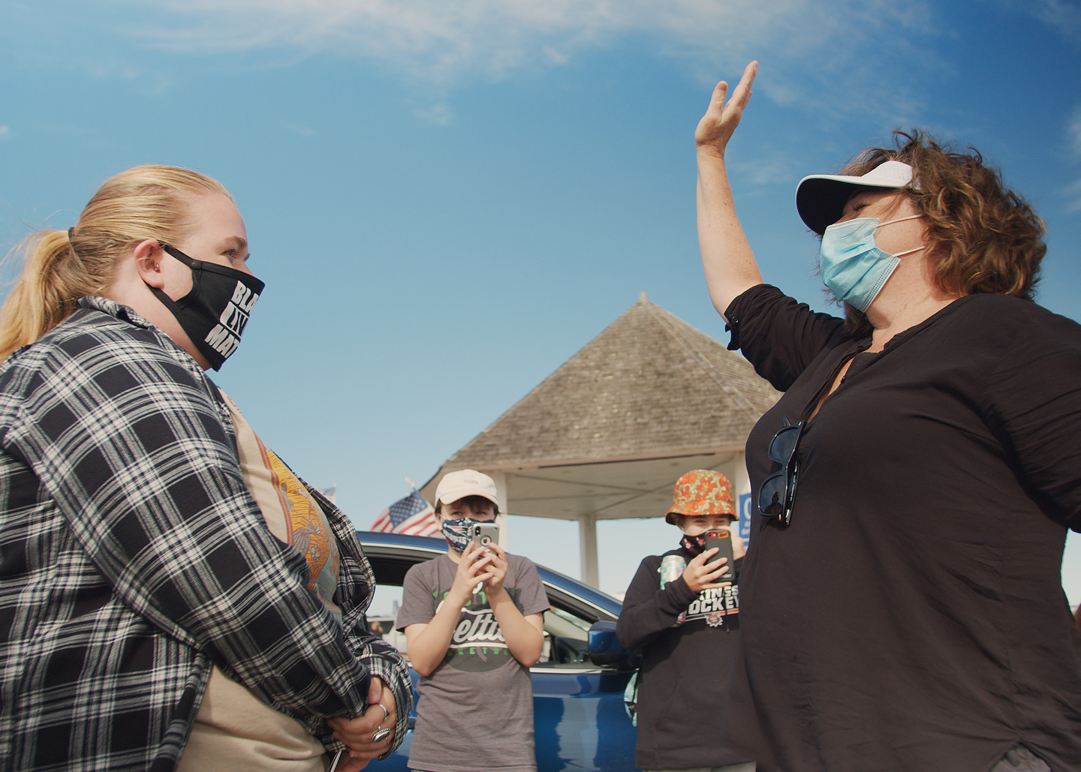 A protestor confronts a bystander exercising her rights in public.